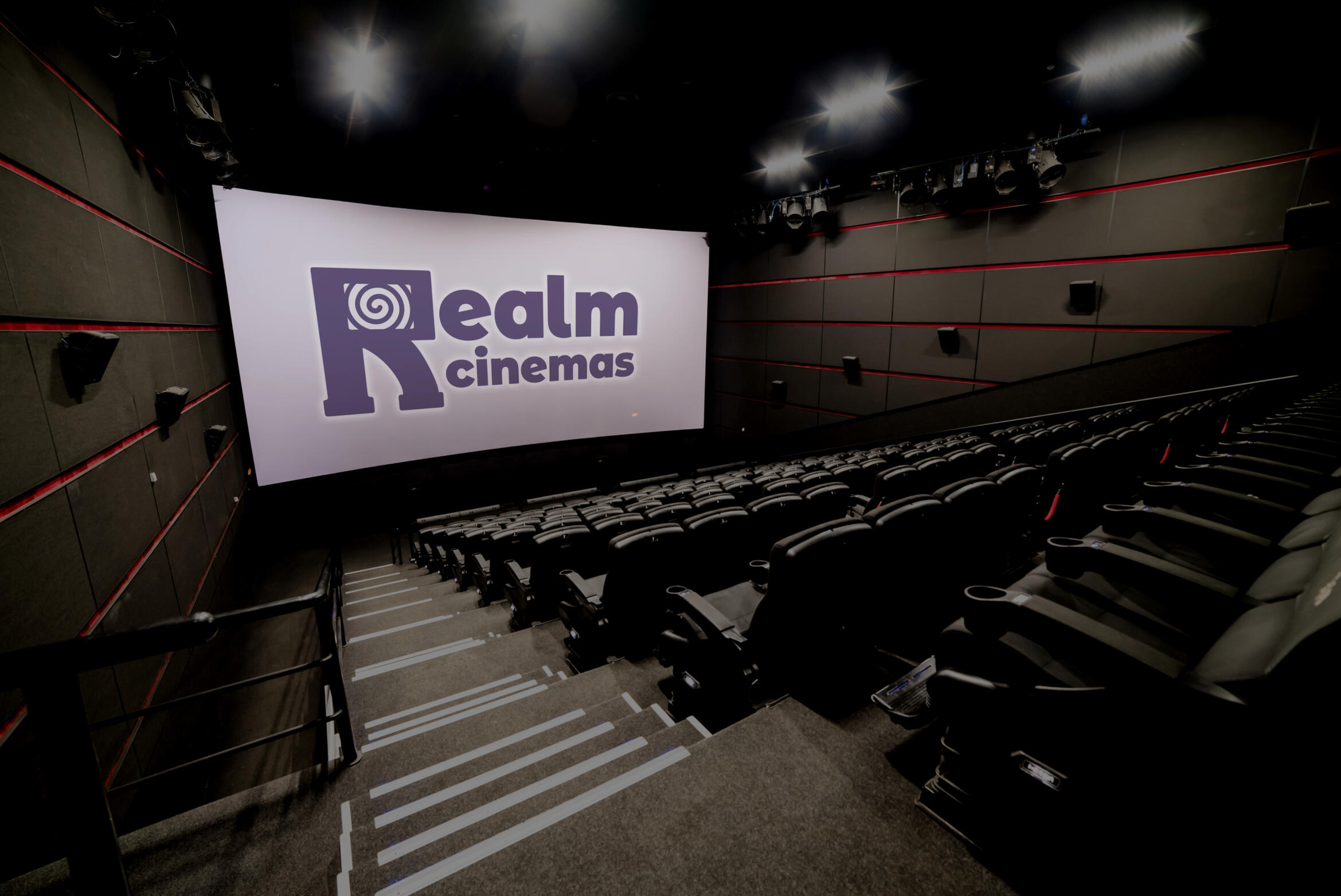 A mockup of a movie theatre with a purple Realm Cinemas logo on the screen.